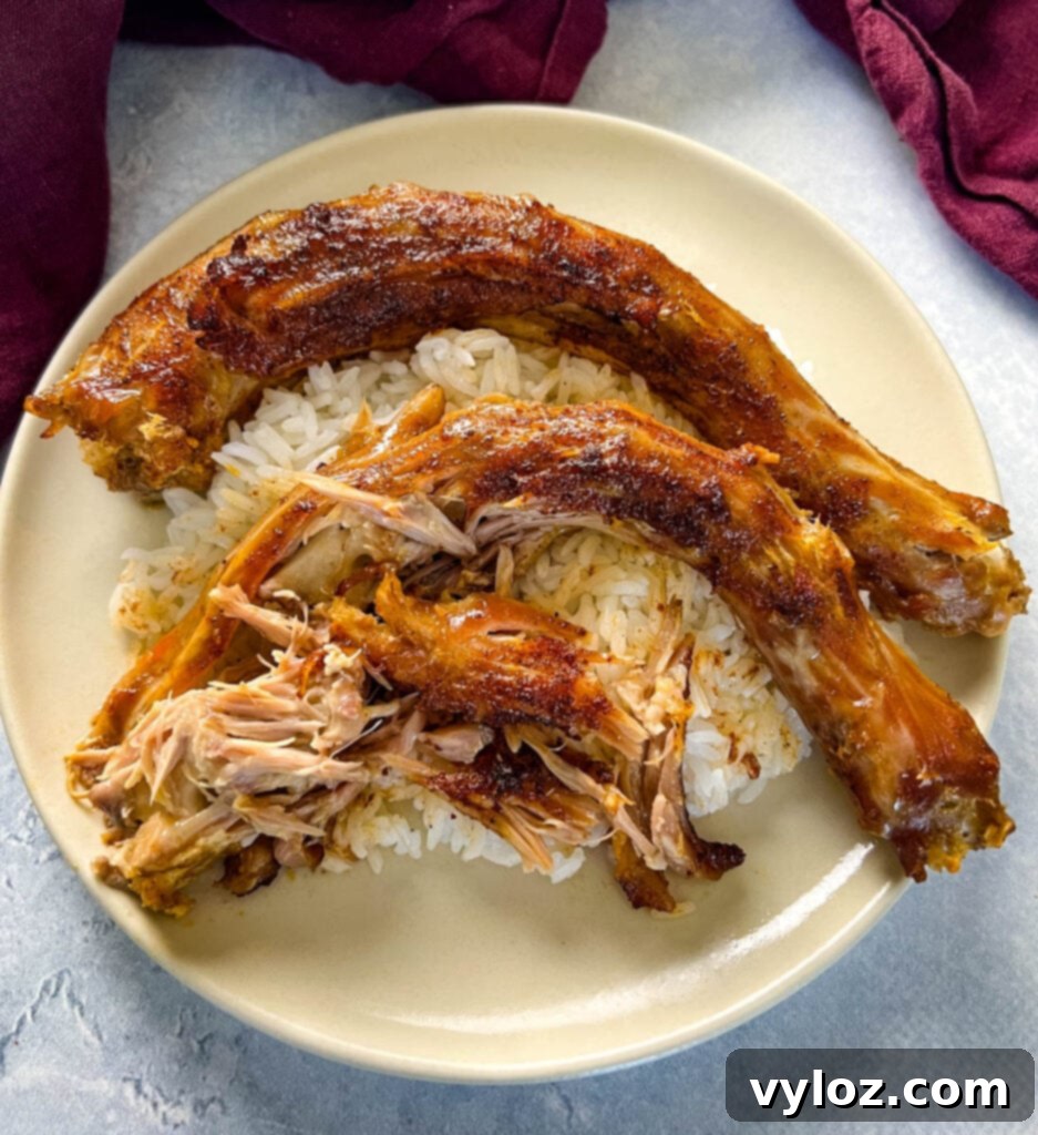 Slow cooker turkey necks served on a plate with white rice