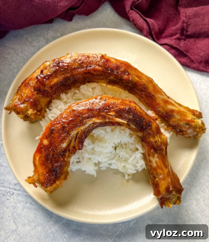 Slow cooker turkey necks served on a plate with white rice and green beans