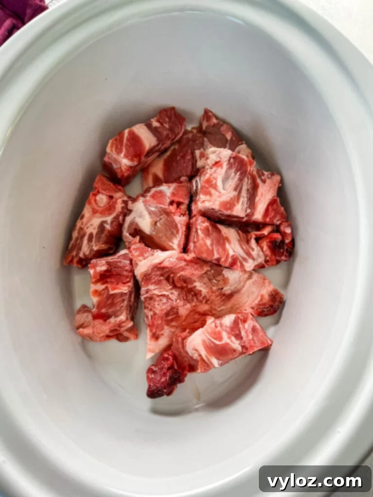 Pork neck bones simmering in a slow cooker, filling the kitchen with a savory aroma