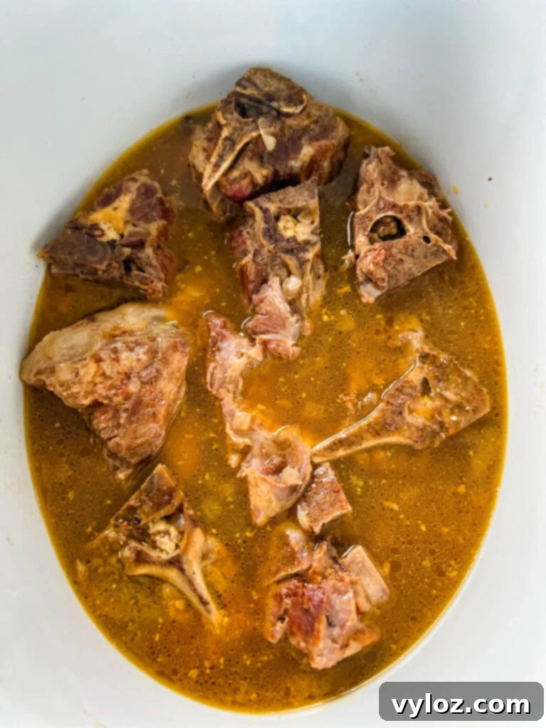 Close-up of tender, fall-off-the-bone neck bones in a Crockpot slow cooker, ready to be served