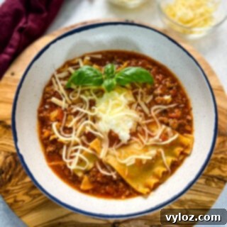 beef lasagna soup with basil and cheese in a bowl