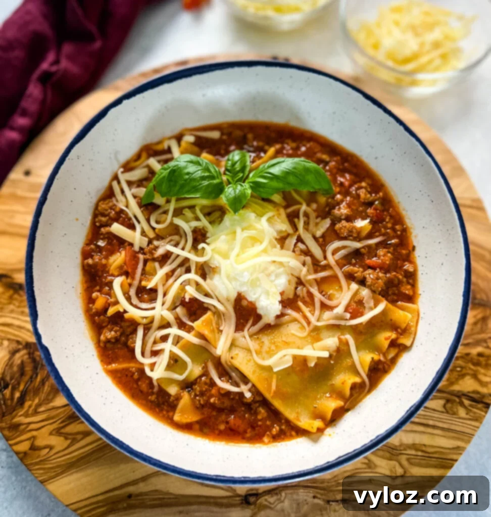 beef lasagna soup with basil and cheese in a bowl, ready for serving