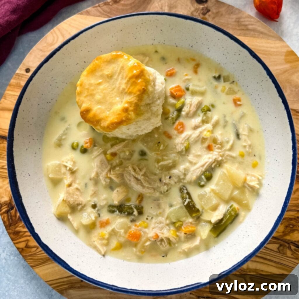 slow cooker crockpot chicken pot pie in a bowl with a biscuit