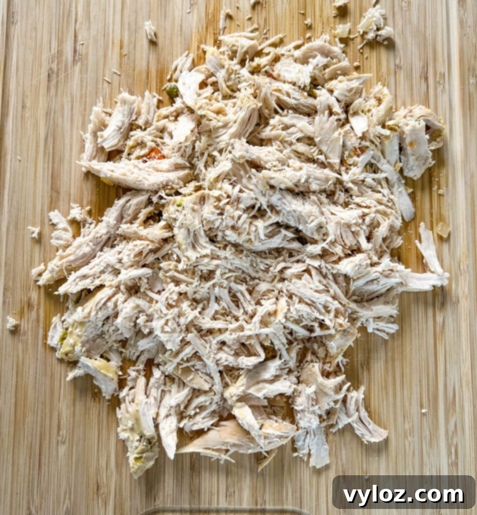 shredded chicken on a bamboo cutting board