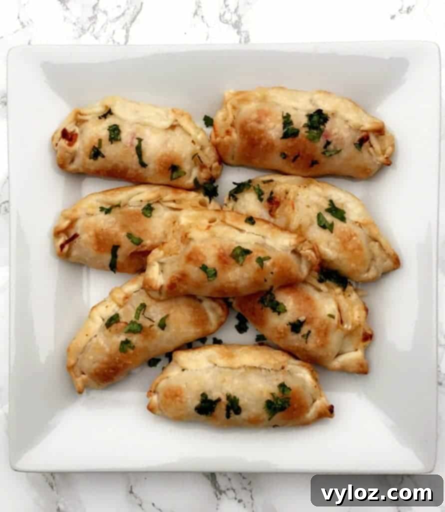 Savory Shrimp Red Pepper Cream Cheese Empanadas 5 A baking tray filled with freshly baked Shrimp Red Pepper Cream Cheese Empanadas
