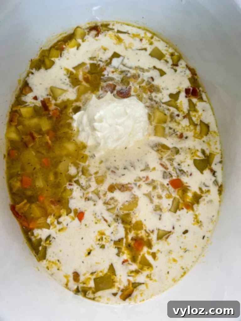 Ultimate Slow Cooker Loaded Potato and Bacon Soup 9 A close-up shot of loaded potato soup simmering, showing its rich, thick texture within the slow cooker.