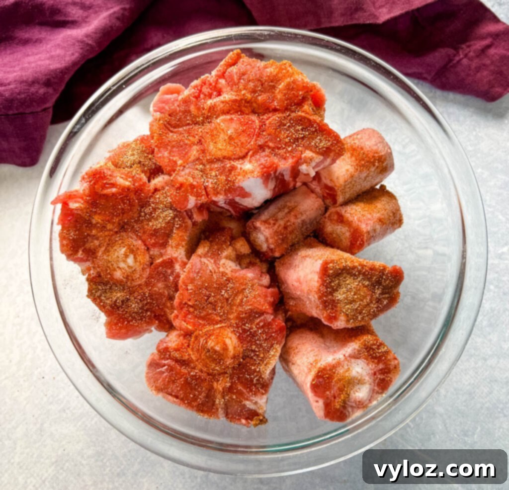 raw seasoned oxtails in a glass bowl