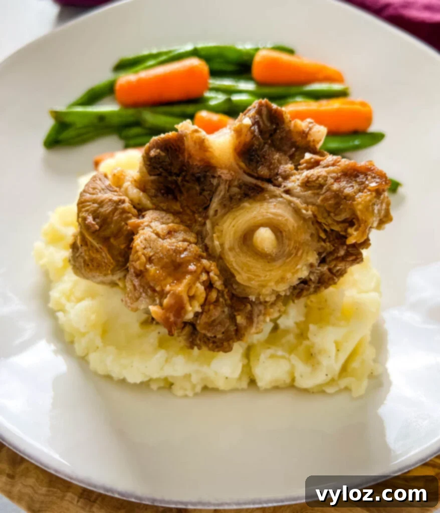 slow cooker crockpot oxtails with mashed potatoes, green beans, and carrots on a plate