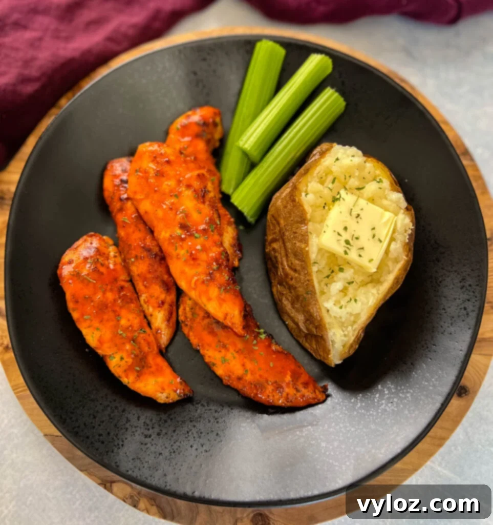 buffalo chicken tenders on a plate with celery, and a baked potato