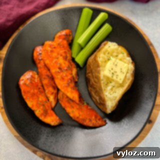 buffalo chicken tenders on a plate with celery, and a baked potato