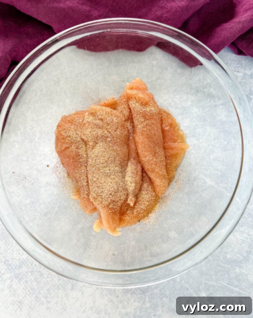raw seasoned chicken tenderloins in a glass bowl