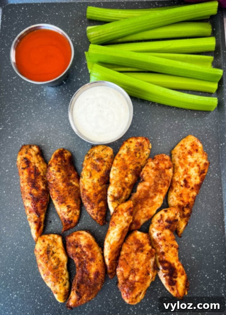 buffalo chicken tenders on a plate with celery, ranch, and buffalo sauce