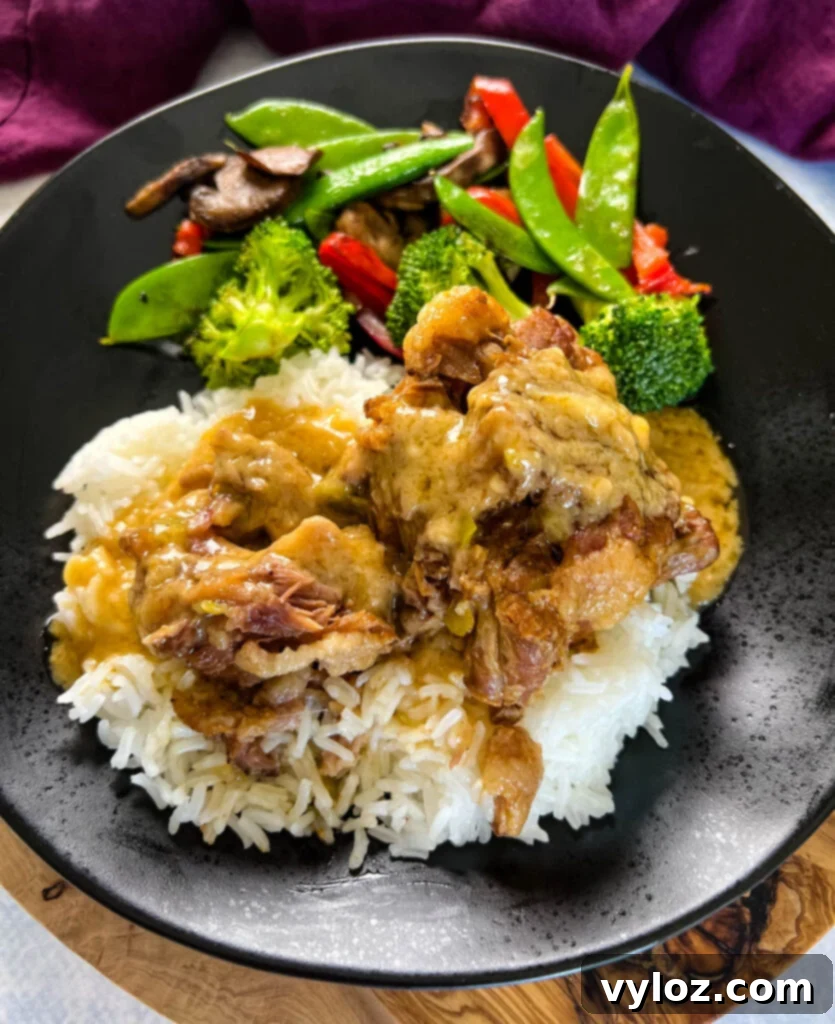 Tender oxtail served on a plate with fluffy white rice, savory gravy, and fresh green vegetables