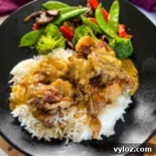 Tender oxtail served on a plate with fluffy white rice, savory gravy, and fresh green vegetables