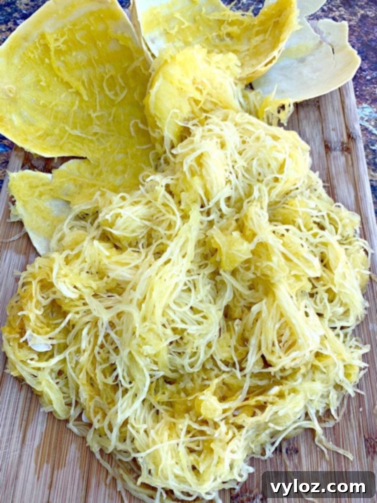 Golden spaghetti squash strands on a wooden cutting board, ready to be served as a healthy pasta alternative.