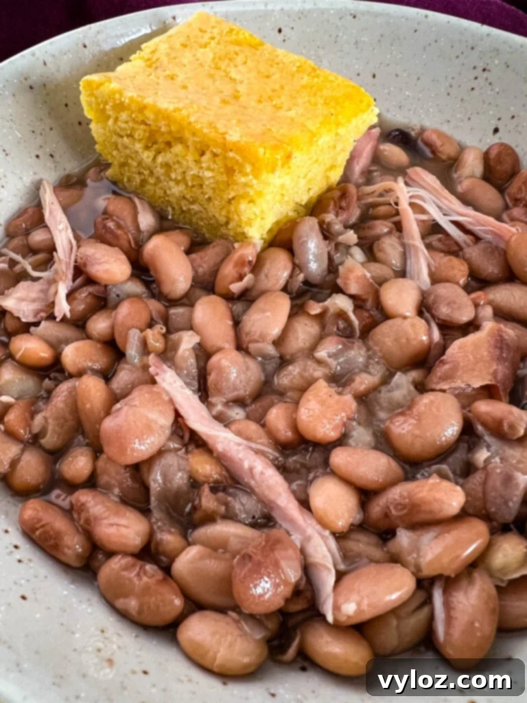 slow cooker crockpot pinto beans in a bowl with cornbread
