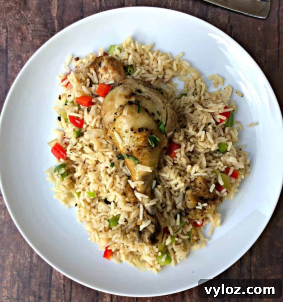 Instant Pot Arroz con Pollo Drumsticks 8 A vibrant bowl of Arroz con Pollo, featuring golden-brown chicken drumsticks and perfectly cooked Spanish rice with flecks of colorful bell peppers.