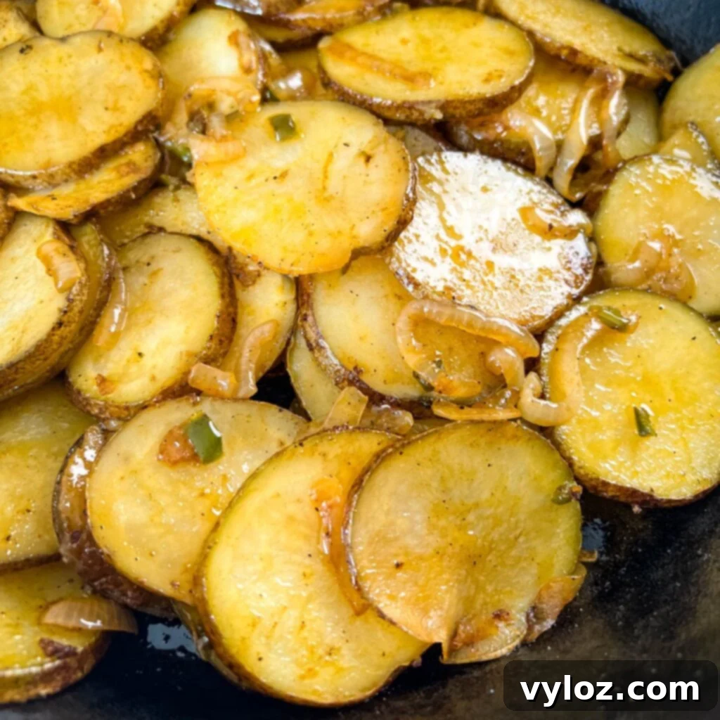 fried potatoes and onions in a cast iron skillet
