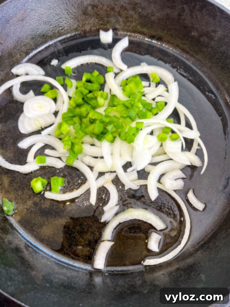 onions and green peppers in a cast iron skillet
