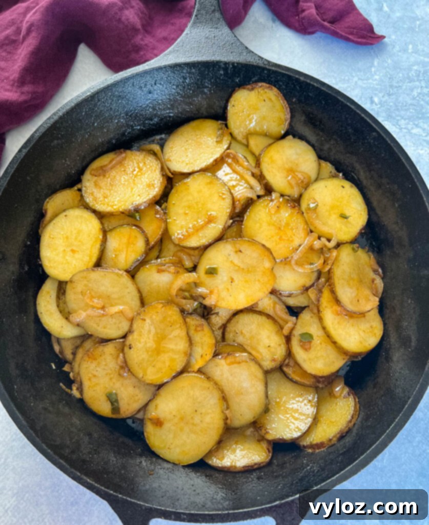 fried potatoes and onions in a cast iron skillet