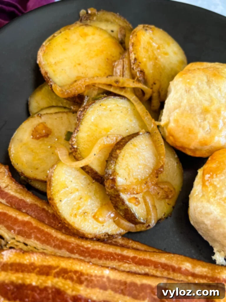 fried potatoes, bacon, and biscuits on a plate
