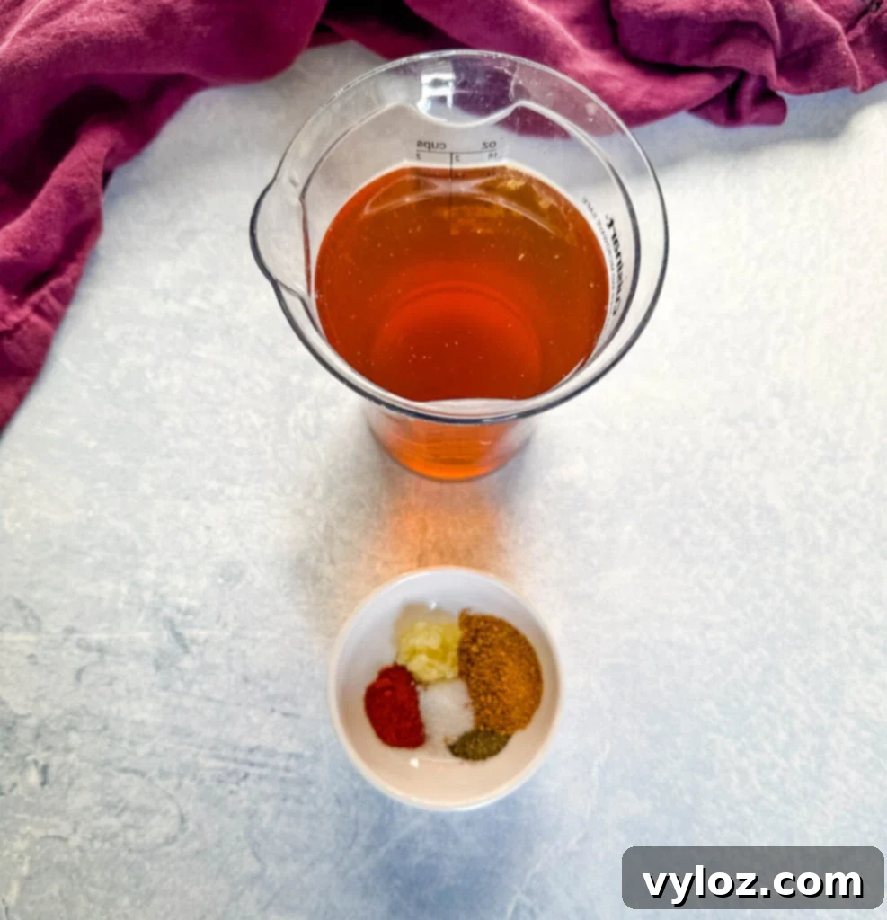Beef broth and various spices displayed in separate bowls