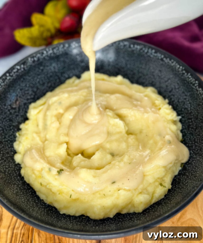 Dripping-Free Golden Gravy 2 yellow gravy without drippings drizzled generously over a bowl of fluffy mashed potatoes