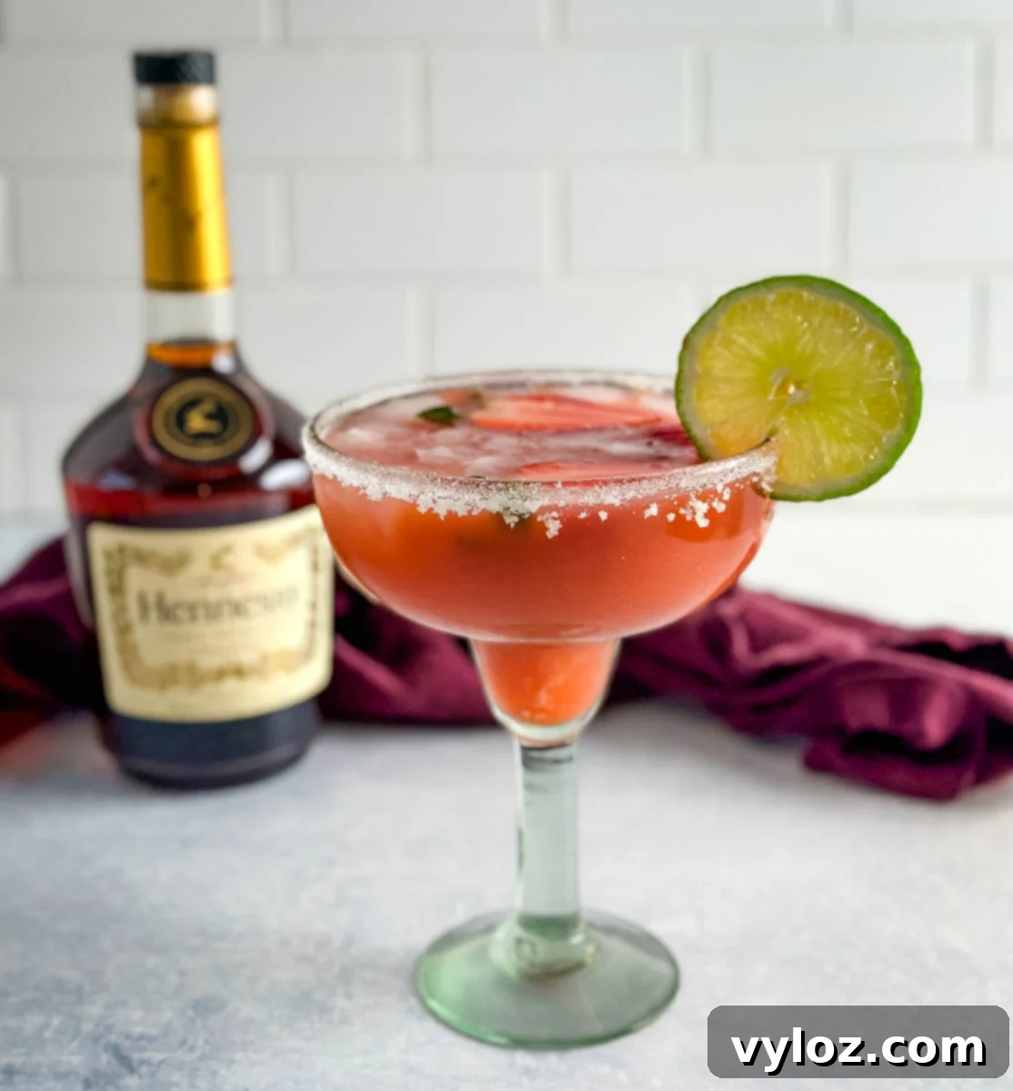 The Ultimate Hennessy Margarita 2 Hennessy margarita in a glass with strawberries and lime