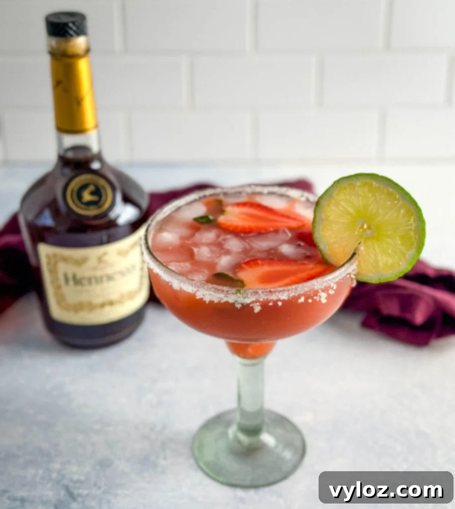 The Ultimate Hennessy Margarita 12 Hennessy margarita in a glass with strawberries and lime