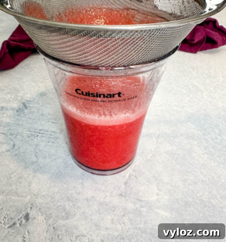 The Ultimate Hennessy Margarita 8 pureed strawberries in a strainer and cup