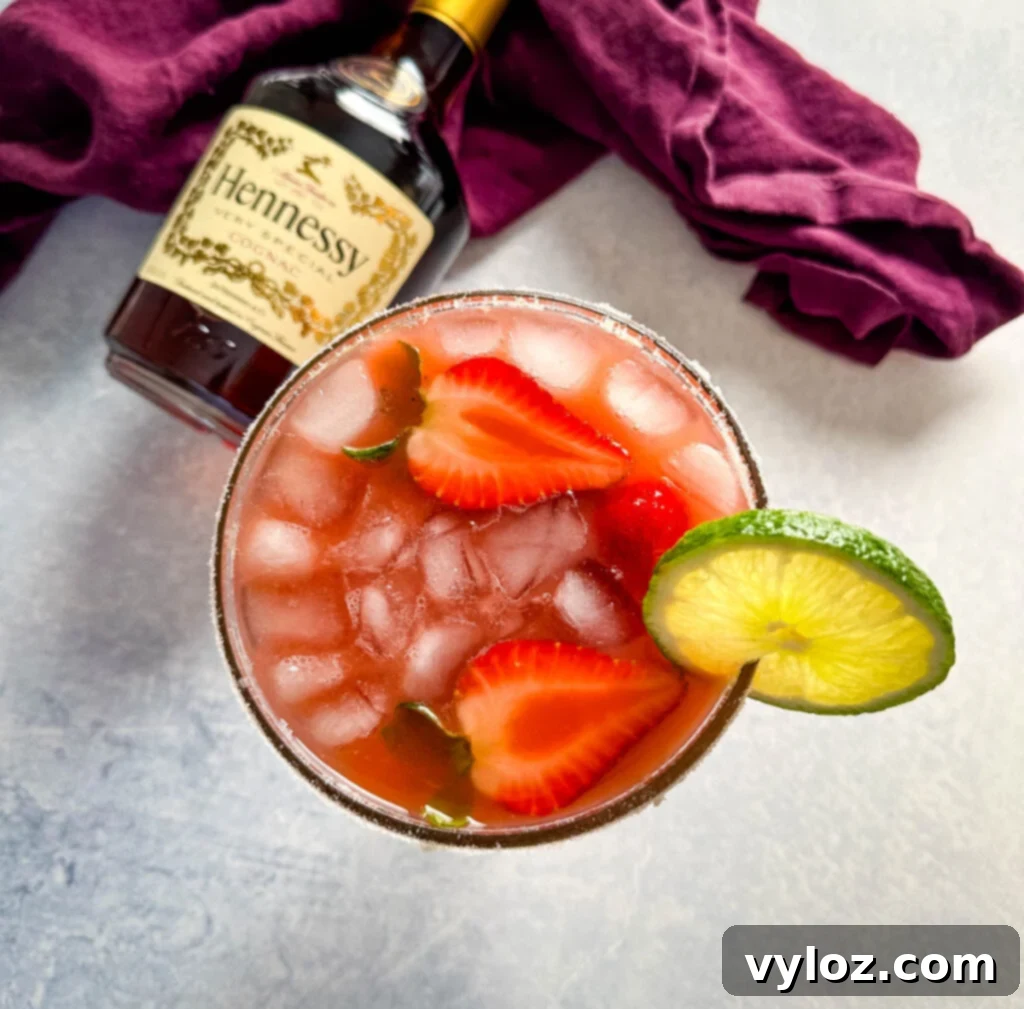 The Ultimate Hennessy Margarita 9 Hennessy margarita in a glass with strawberries and lime