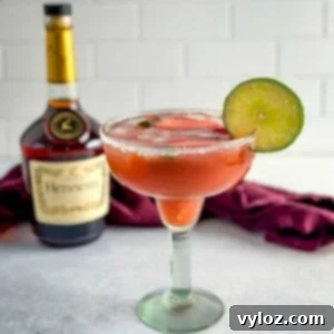 The Ultimate Hennessy Margarita 10 Hennessy margarita in a glass with strawberries and lime