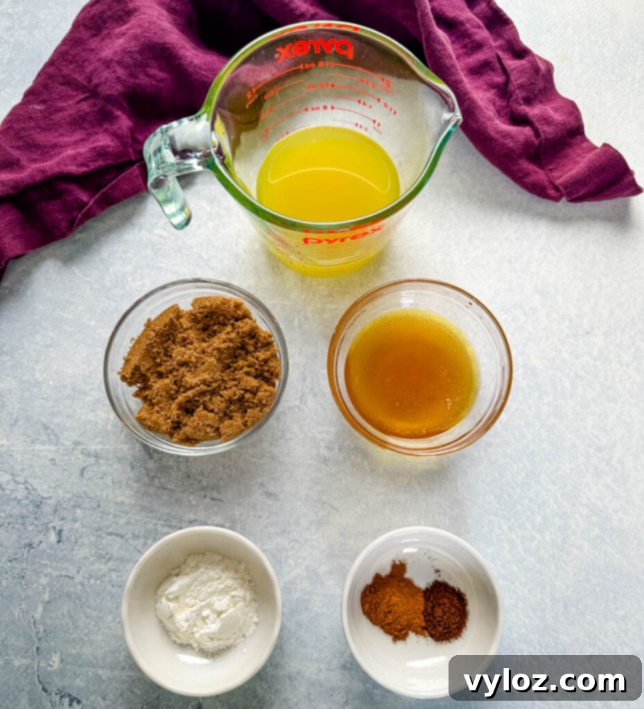 Ingredients for ham glaze including pineapple juice, brown sugar, honey, cornstarch, cinnamon, and cloves laid out in separate bowls