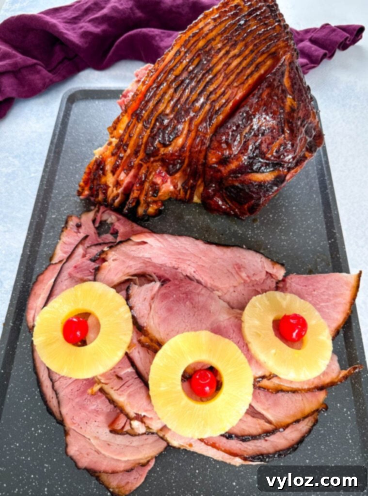 Traeger smoked ham sliced on a serving platter with pineapple rings and cherries for garnish
