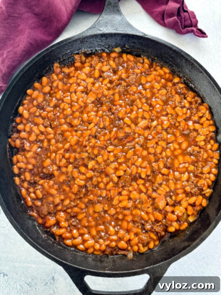 smoked baked beans with ground beef and bacon in a cast iron skillet