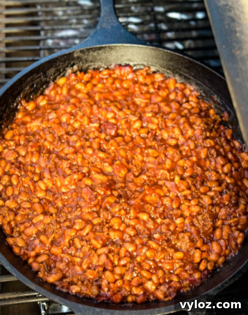smoked baked beans with ground beef and bacon in a cast iron skillet