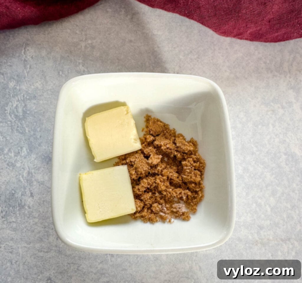 Butter and brown sugar in a white bowl, ready to top smoked sweet potatoes.
