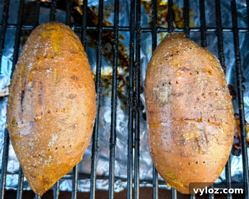 Sweet potatoes cooking on a smoker grill, absorbing smoky flavor.