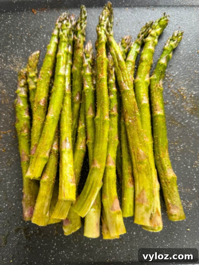 Wood-Kissed Asparagus 5 fresh asparagus with spices on a plate