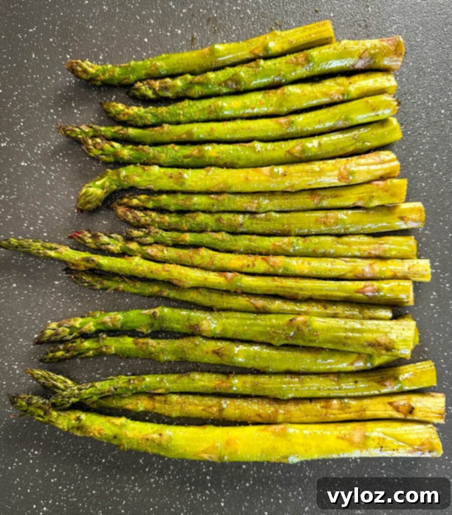 Wood-Kissed Asparagus 6 fresh asparagus with spices on a plate