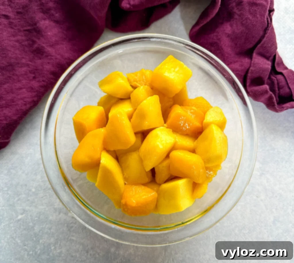 frozen thawed mango sliced into chunks in a glass bowl