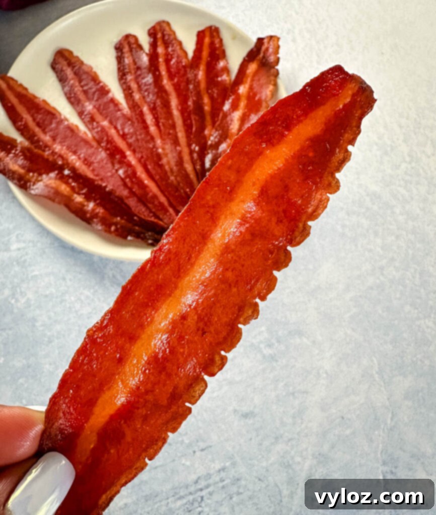 person holding slice of baked turkey bacon