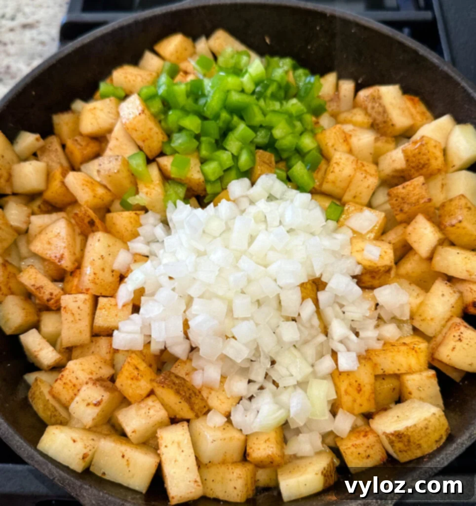 Savory Slow-Cooked Potatoes and Onions 6 Close-up of fried potatoes, onions, and peppers in a cast iron skillet, nicely caramelized