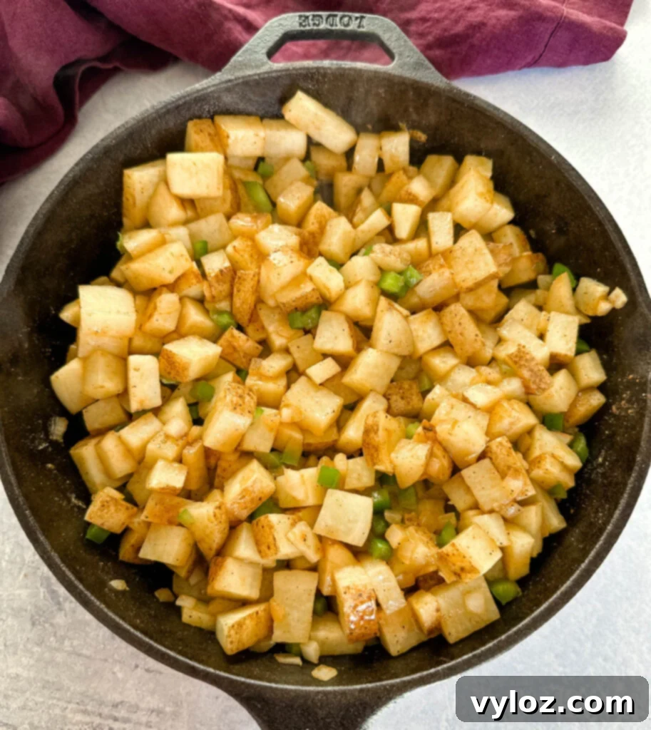 Savory Slow-Cooked Potatoes and Onions 7 Cooked potatoes, onions, and peppers in a cast iron skillet, ready for gravy