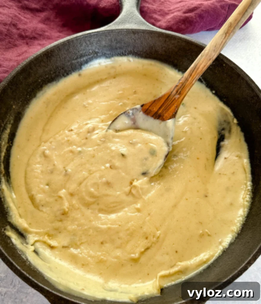 Savory Slow-Cooked Potatoes and Onions 10 Homemade gravy simmering in a cast iron skillet with a wooden spoon, thick and rich