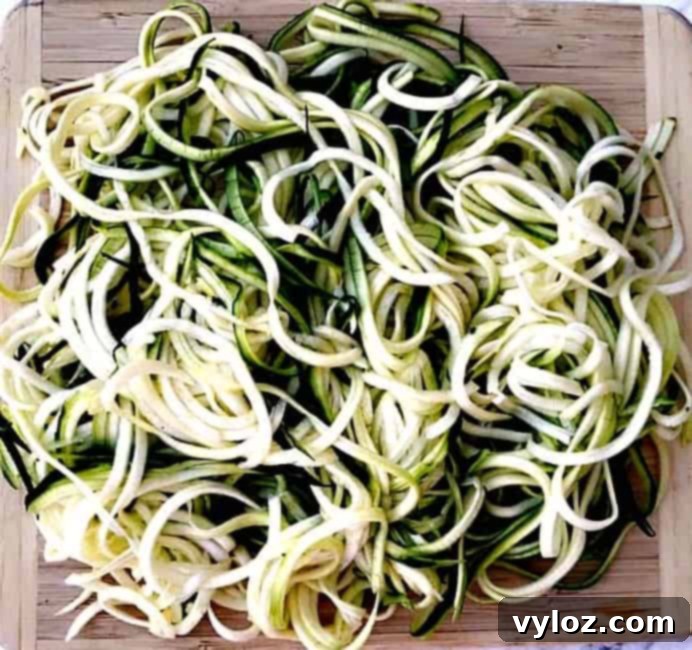 Spiralized zucchini noodles arranged on a cutting board, ready for a low-carb Mediterranean shrimp dish