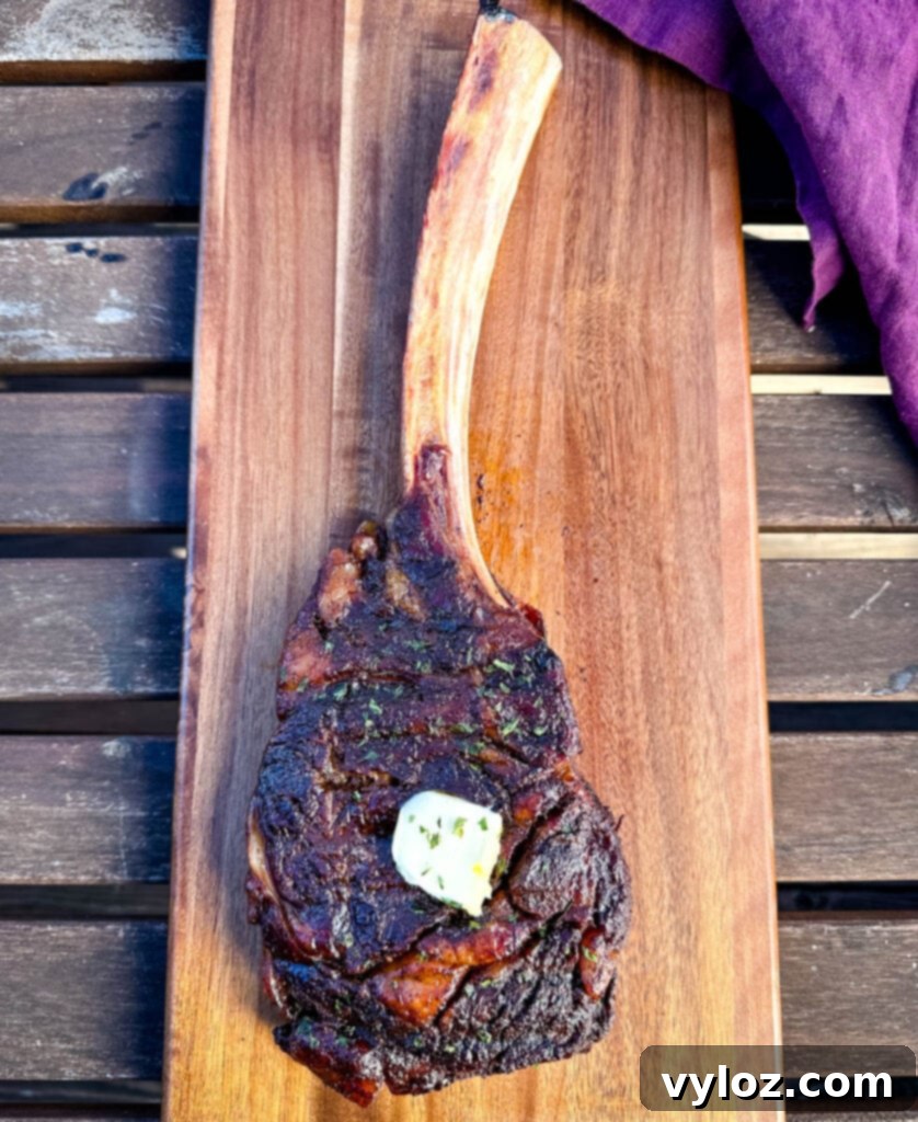 smoked tomahawk steak with butter on a platter