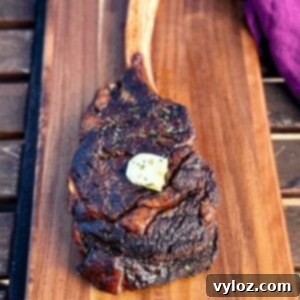 smoked tomahawk steak with butter on a platter