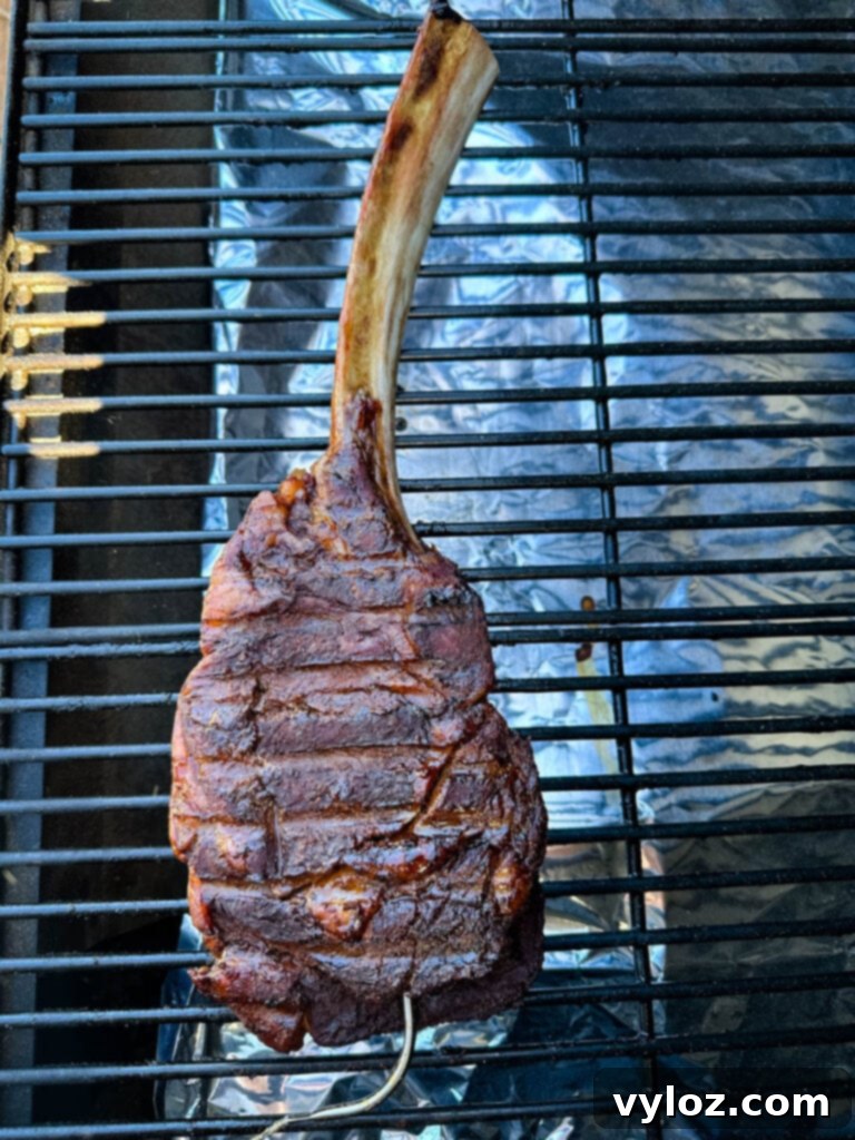 smoked tomahawk steak with butter on a Traeger pellet grill