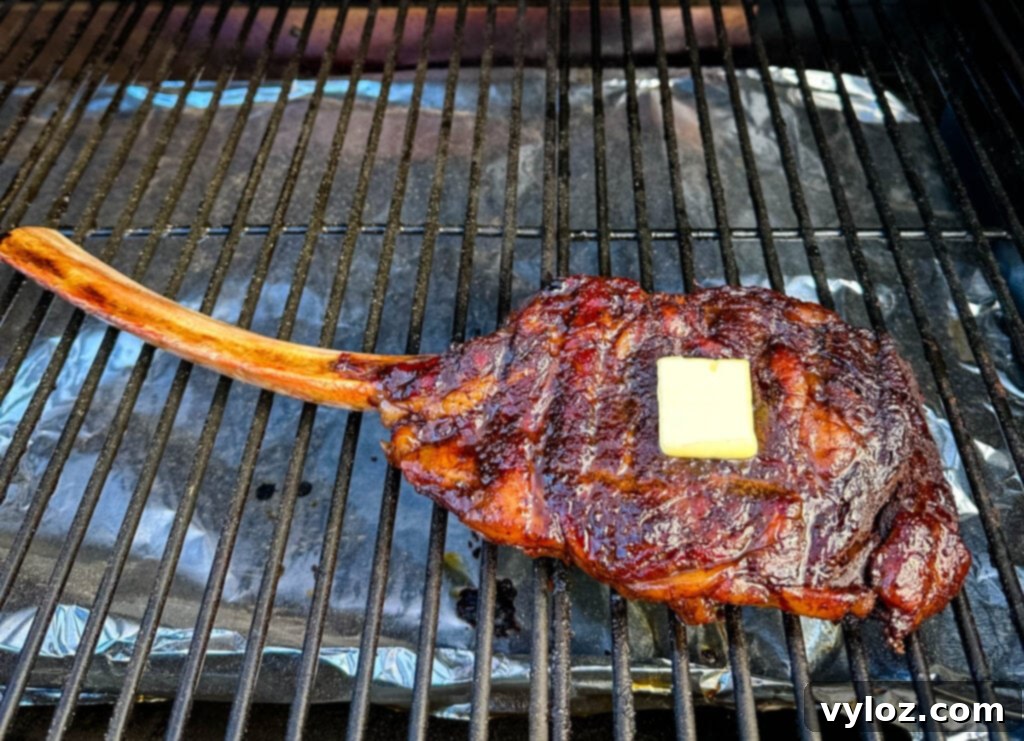 smoked tomahawk steak with butter on a Traeger pellet grill